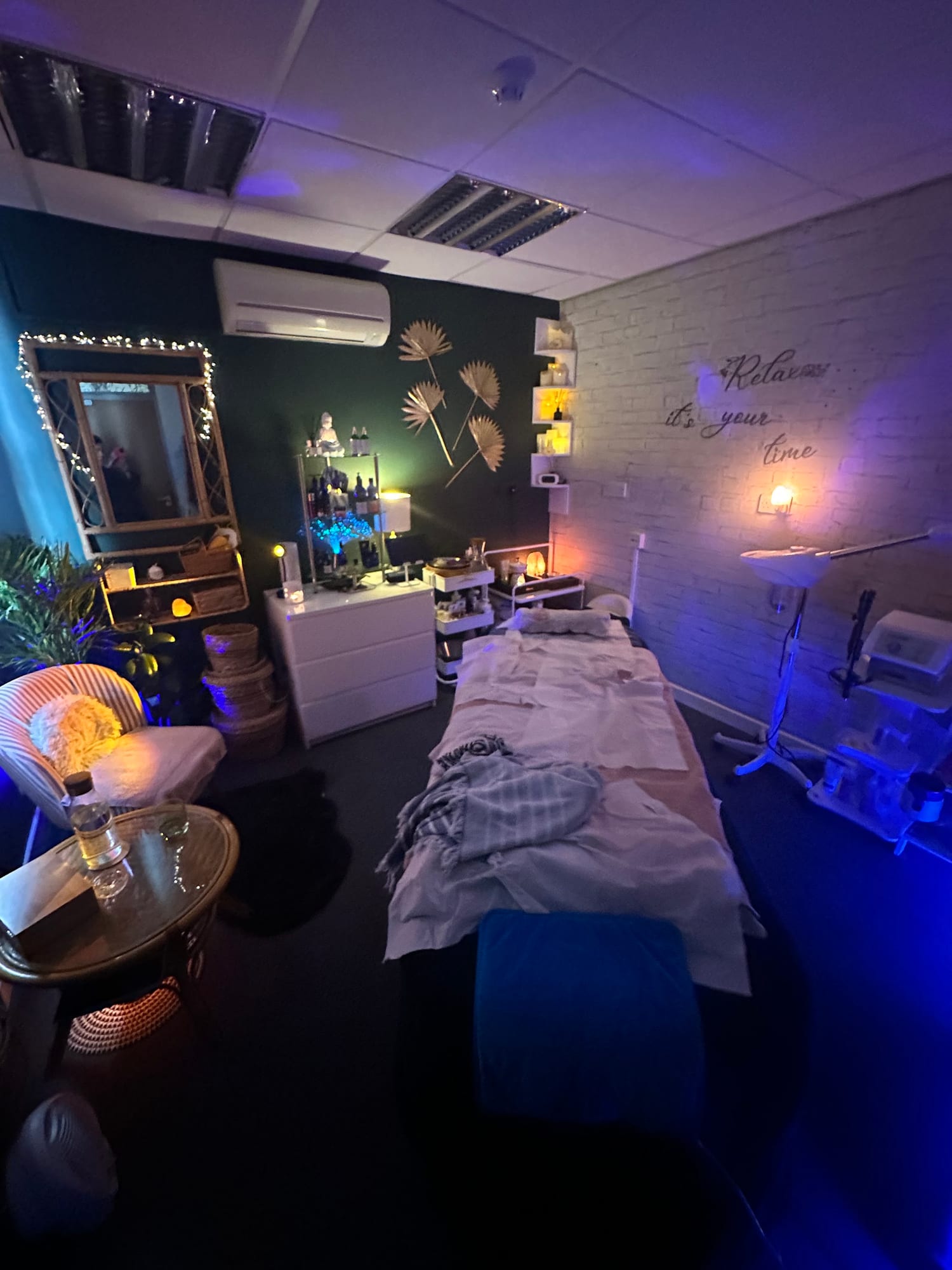 The cosy iplace treatment suite with warm lamps and a prepared massage bed